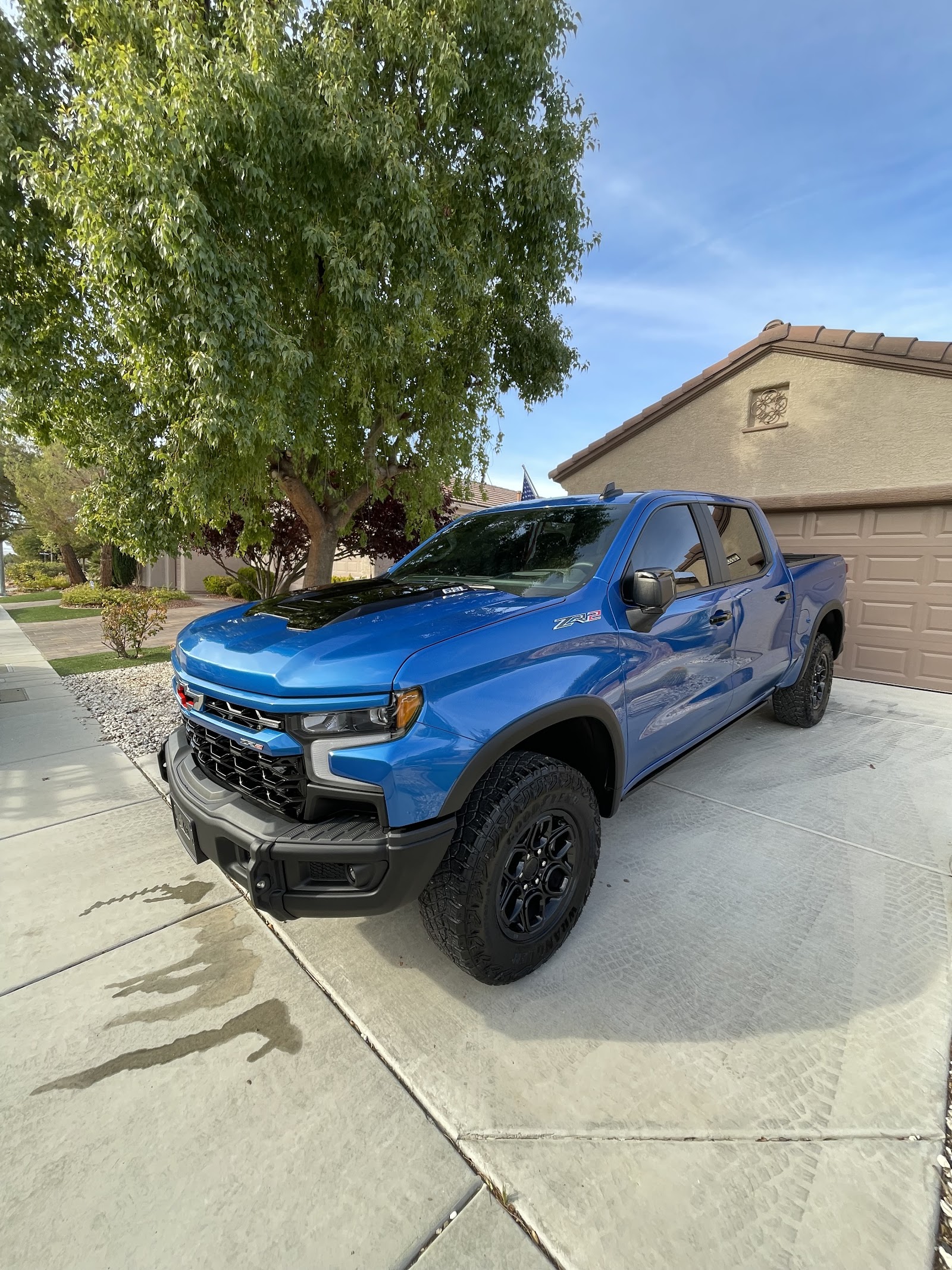 Blue Chevrolet Silverado ZR2 truck detailed and shiny in a driveway